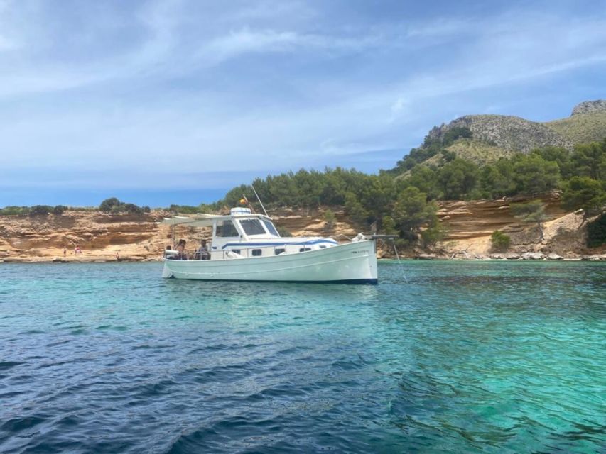 Alcudia: Traditional Wooden Boat Trip with Snorkeling - The cruise views: cliffs, Aucanada lighthouse, and passing Cap Menorca