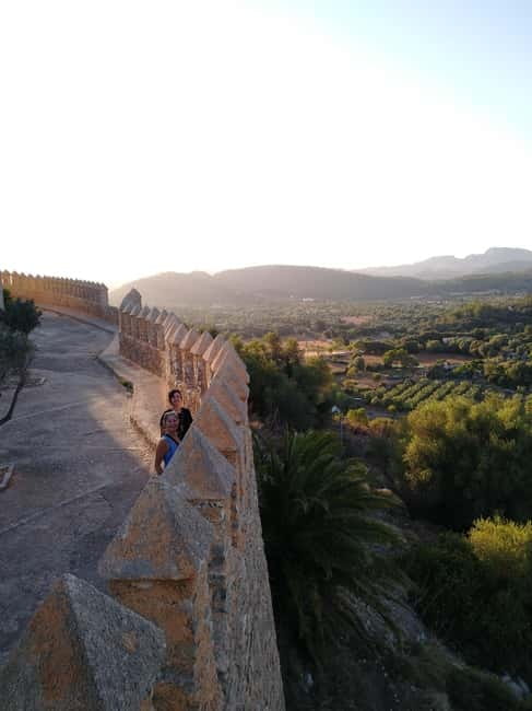 Travel and play tennis in Mallorca - Entering Artà: fortress walls, local shops, and real walking time
